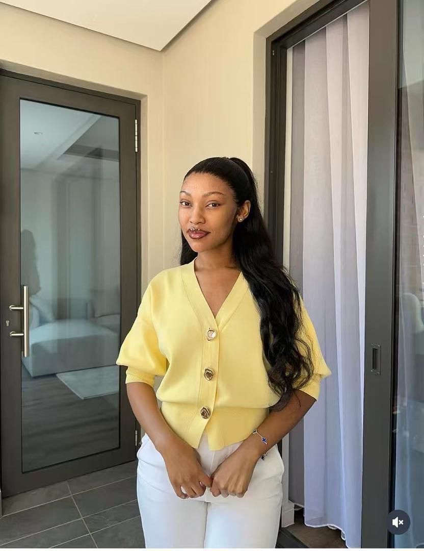 A knitted cardigan or sweater top characterised by its prominent silver/gold-tone heart-shaped buttons and has a slightly cropped length with long, voluminous balloon sleeves that end in ribbed cuffs.