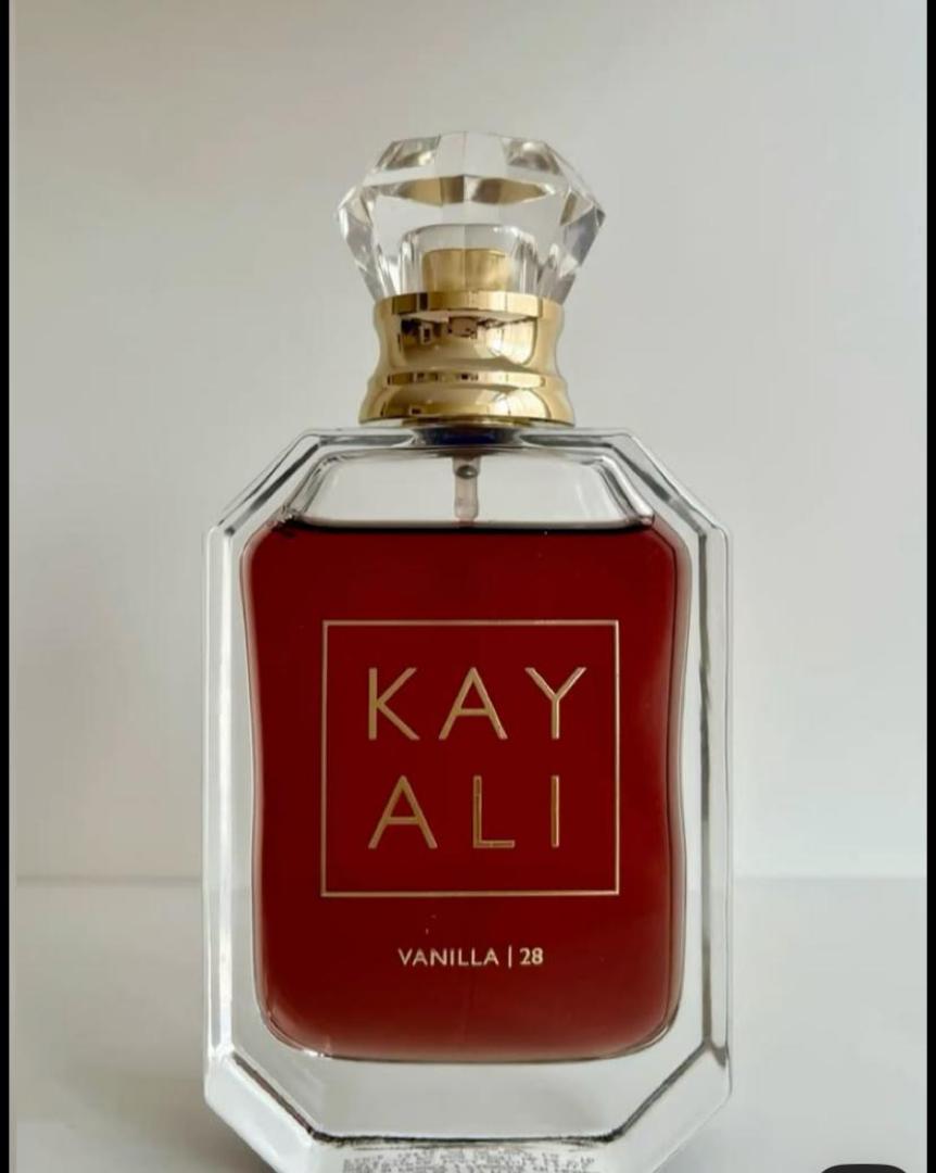 100Ml Kayali Vanilla | 28 perfume in a faceted glass bottle with gold accents and a crystal-like cap. Deep amber-red juice inside. The label shows "KAY ALI" in gold within a square frame.