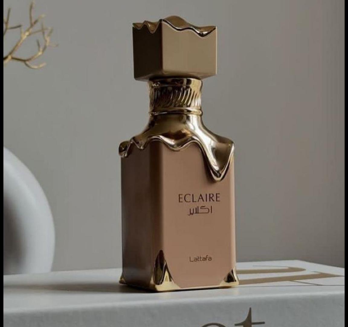 50 Ml Lattafa Eclaire Pink bottle with gold drip. Creamy gourmand scent of caramel, milk, honey, vanilla. Sweet, cozy, dessert-like.