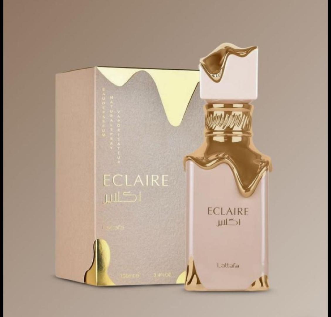 50 Ml Lattafa Eclaire Pink bottle with gold drip. Creamy gourmand scent of caramel, milk, honey, vanilla. Sweet, cozy, dessert-like.