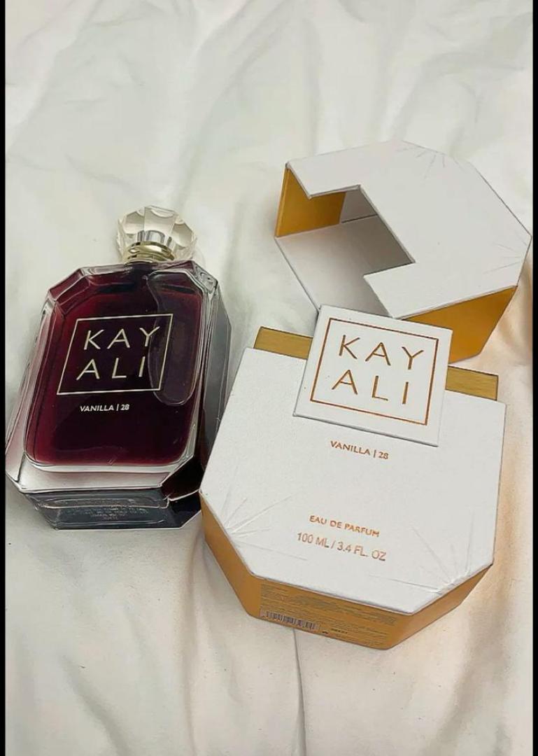 100Ml Kayali Vanilla | 28 perfume in a faceted glass bottle with gold accents and a crystal-like cap. Deep amber-red juice inside. The label shows "KAY ALI" in gold within a square frame.
