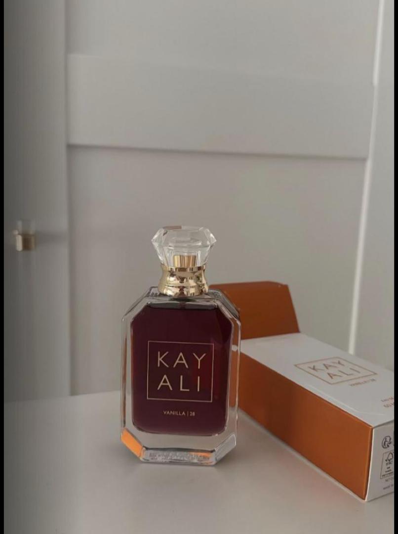 100Ml Kayali Vanilla | 28 perfume in a faceted glass bottle with gold accents and a crystal-like cap. Deep amber-red juice inside. The label shows "KAY ALI" in gold within a square frame.