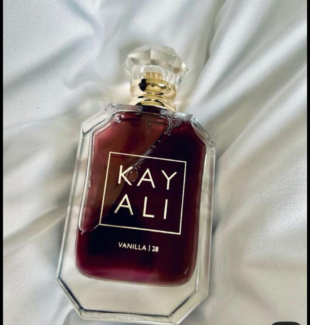 100Ml Kayali Vanilla | 28 perfume in a faceted glass bottle with gold accents and a crystal-like cap. Deep amber-red juice inside. The label shows "KAY ALI" in gold within a square frame.
