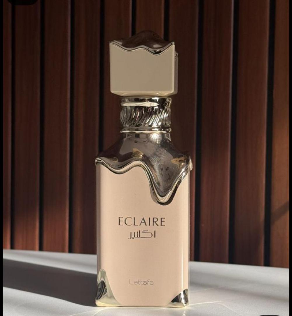 50 Ml Lattafa Eclaire Pink bottle with gold drip. Creamy gourmand scent of caramel, milk, honey, vanilla. Sweet, cozy, dessert-like.