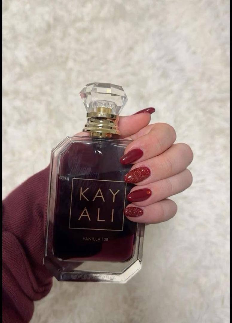 100Ml Kayali Vanilla | 28 perfume in a faceted glass bottle with gold accents and a crystal-like cap. Deep amber-red juice inside. The label shows "KAY ALI" in gold within a square frame.