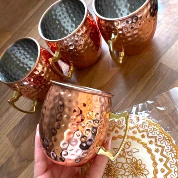 copper Moscow Mule mugs featuring brass handles and a polished finish mugs are traditionally used for serving Moscow Mules because the copper helps keep the drink chilled to enhance flavour .